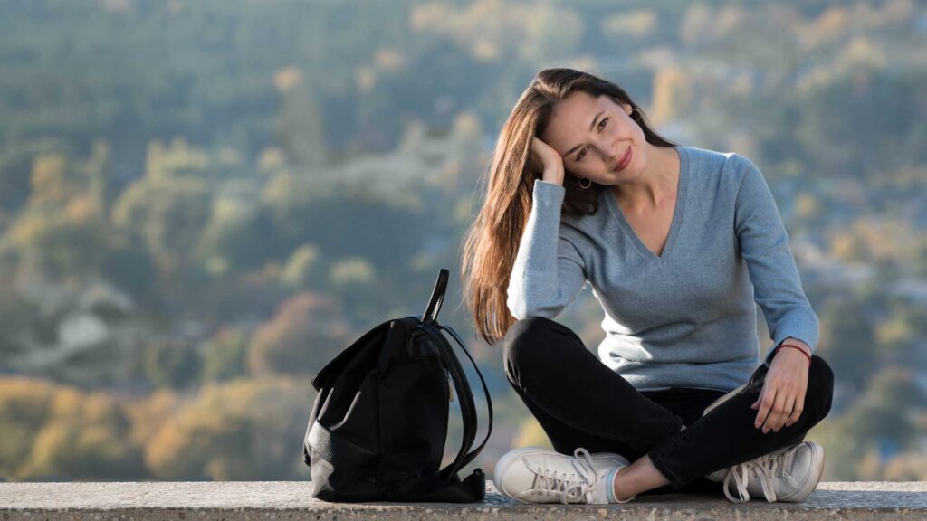 Smiling Beautiful Girl with a Backpack Outdoors