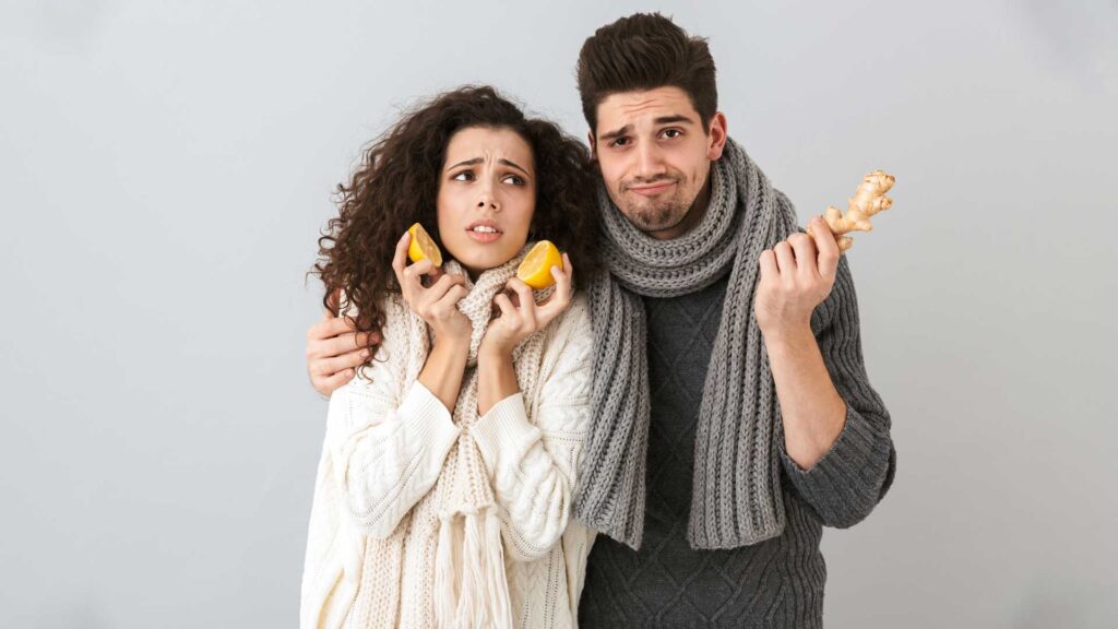 Young Couple Wearing Scarfs Holding Lemons and Ginger Cant Stop Thinking About Her