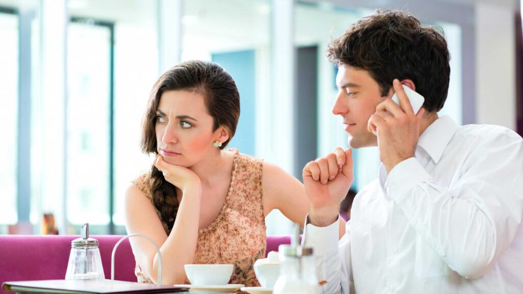 A Young Couple in the Café sat in Silence, Seemingly Engaged in the Act of Monkey Branching